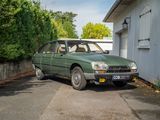 une voiture verte garée devant un immeuble