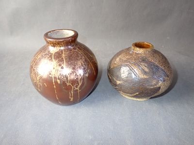 two vases sitting side by side on a gray surface