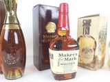 Plusieurs bouteilles de whisky sont posées sur une table, à côté d'une boîte