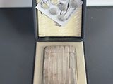 a silver cigarette case with a silver cigarette in it