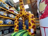 une grande girafe gonflable au milieu d'un entrepôt