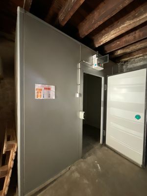 une pièce avec une échelle et un mur sur lequel est accrochée une pancarte