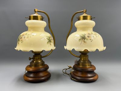 paire de lampes anciennes sur des socles en bois ornés de motifs floraux