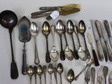 many spoons and forks laid out on the table