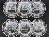 six assiettes sur lesquelles est représenté un bateau, posées sur une table