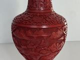 un vase rouge posé sur une table