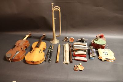 un violon, une trompette, un étui à violon et d'autres instruments de musique disposés sur une table