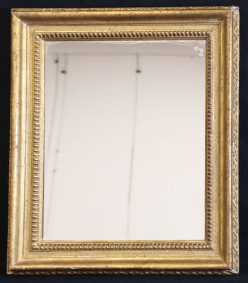 an antique gold framed mirror with a black background
