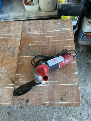 a red and black power tool on a wooden table