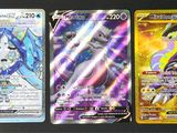 trois cartes Pokémon différentes posées sur une table avec un fond noir