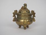 an old brass incense pot with a bird on top