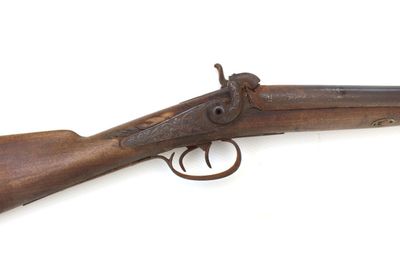 un vieux fusil exposé sur une surface blanche