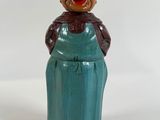 a figurine of a woman wearing a green apron