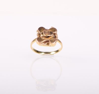 Gros plan sur une bague en or ornée d'une fleur