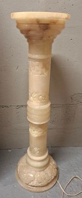 a white pedestal that has a light on top of it