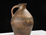 a large brown vase sitting on a white table