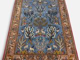 un tapis bleu orné d'oiseaux et de fleurs