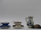 three cups and a saucer sitting on a table