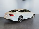 the rear end of a white audi sedan parked in a garage