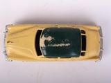 a yellow toy car that is sitting on a white surface