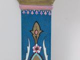 a blue and pink vase on a stand on a white surface