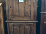 une grande armoire en bois avec un bol de nourriture posé par terre