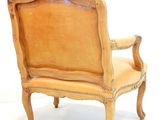 a wooden chair with a tan upholstered seat