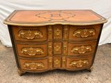 une image représentant une commode en bois ornée de motifs dorés