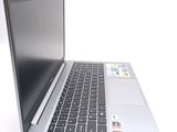 a silver laptop with a black keyboard on a white surface