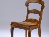une image représentant une chaise en bois avec une assise en cuir sur fond blanc