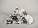 quelques cristaux blancs et noirs reposent sur un morceau de roche