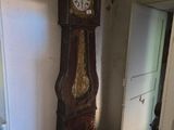 une horloge de parquet qui se trouve dans un coin de la pièce