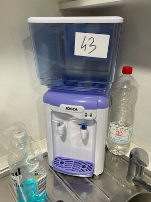 un distributeur d'eau posé sur un plan de travail à côté d'un évier