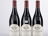 trois bouteilles de vin rouge posées côte à côte sur une table