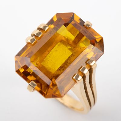 Gros plan sur une bague contenant une pierre jaune