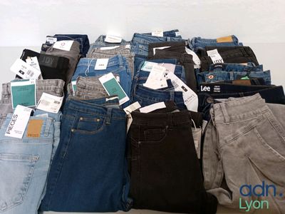 several pairs of jeans are stacked on top of each other on a table