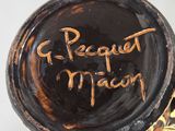 a brown vase with writing on it sitting on a table