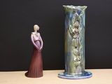 a vase and a figurine sitting on a table
