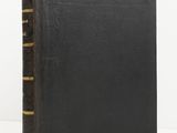 an old black book with gold trims on a white background