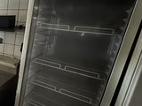 a refrigerator that is open in a kitchen with tile flooring
