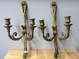 trois chandeliers en laiton posés sur une table en bois dans une pièce