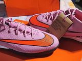 des chaussures Nike roses et orange exposées dans un magasin de chaussures