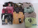 a lot of sweaters that are sitting on a table