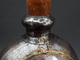 a silver vase with a wooden handle on a table