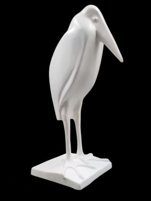 a white statue of a bird that is standing on a base