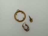 two gold rings and a pair of earrings on a table