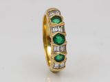 a close up of a gold ring with emeralds and diamonds