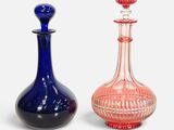 pair of blue and pink glass bottles with a red stopper