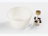 the bowl is white with a gold rim and is next to a bottle of wine