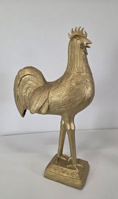 brass rooster figurine on stand on white background